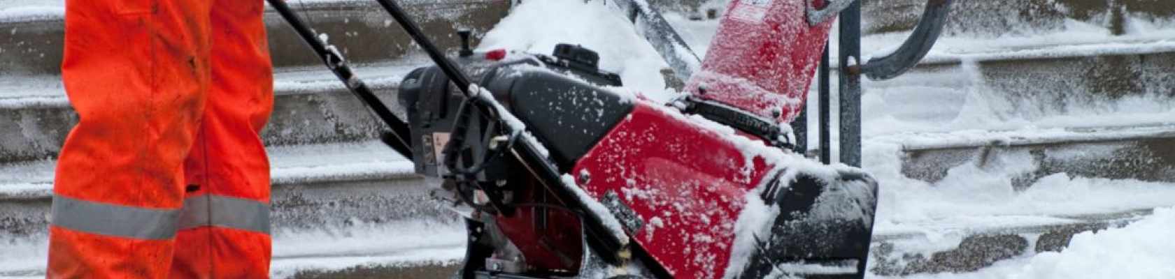 Image of maintenance worker clearing snow in front of a recreation facility