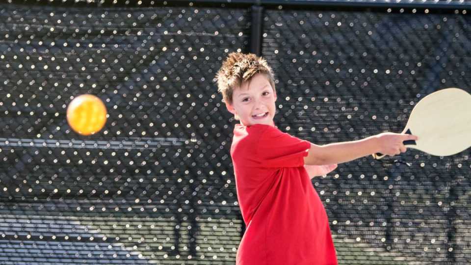 image of teenager playing on a maintained pickleball court