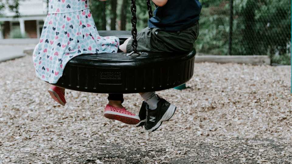 Children swinging on a safe, maintained playground